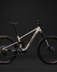 Santa Cruz full-suspension mountain bike in a light beige frame with black components, shown in profile against a dark studio background.