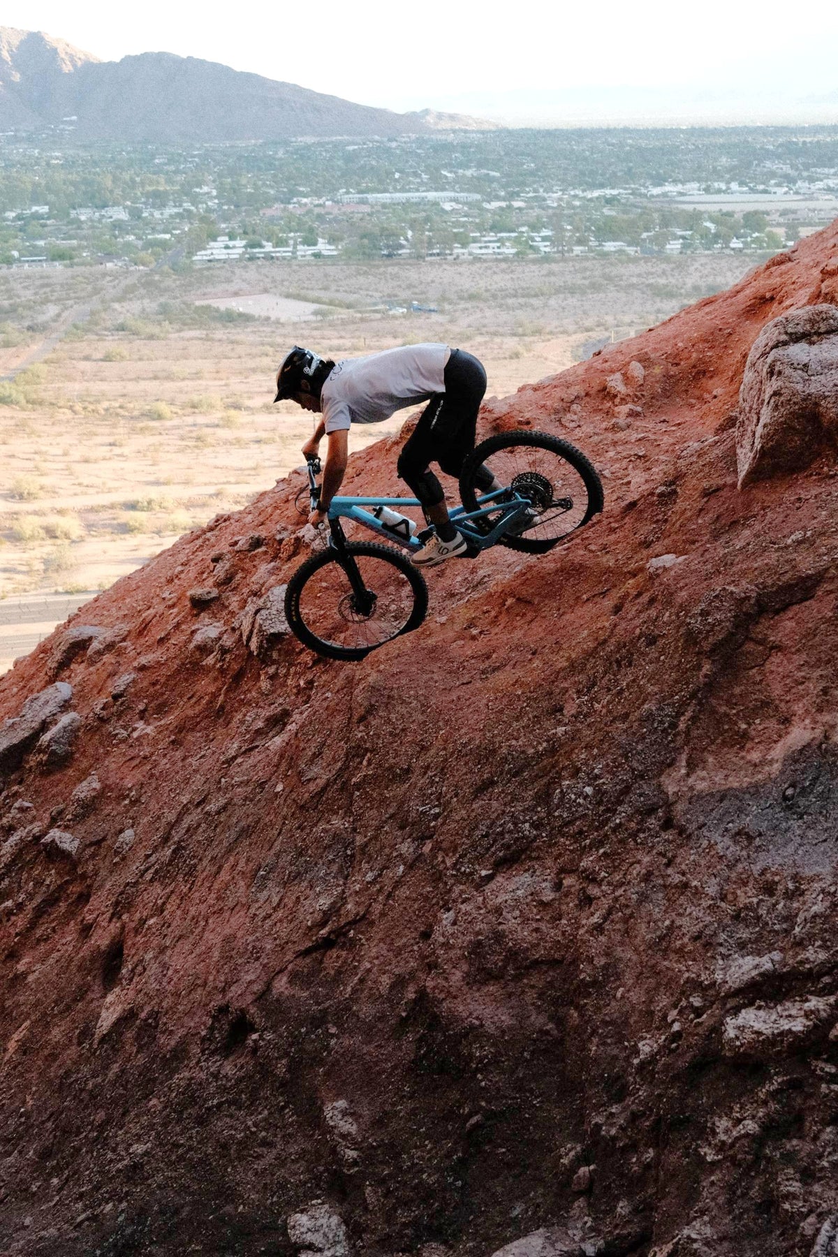 Rider descending a steep red rock slope on a 2027 Santa Cruz Nomad in Arizona