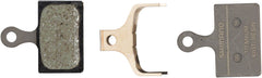 Pastillas de freno de disco Shimano K05Ti-RX con resortes y compuesto de resina, placa trasera de titanio (un par)
